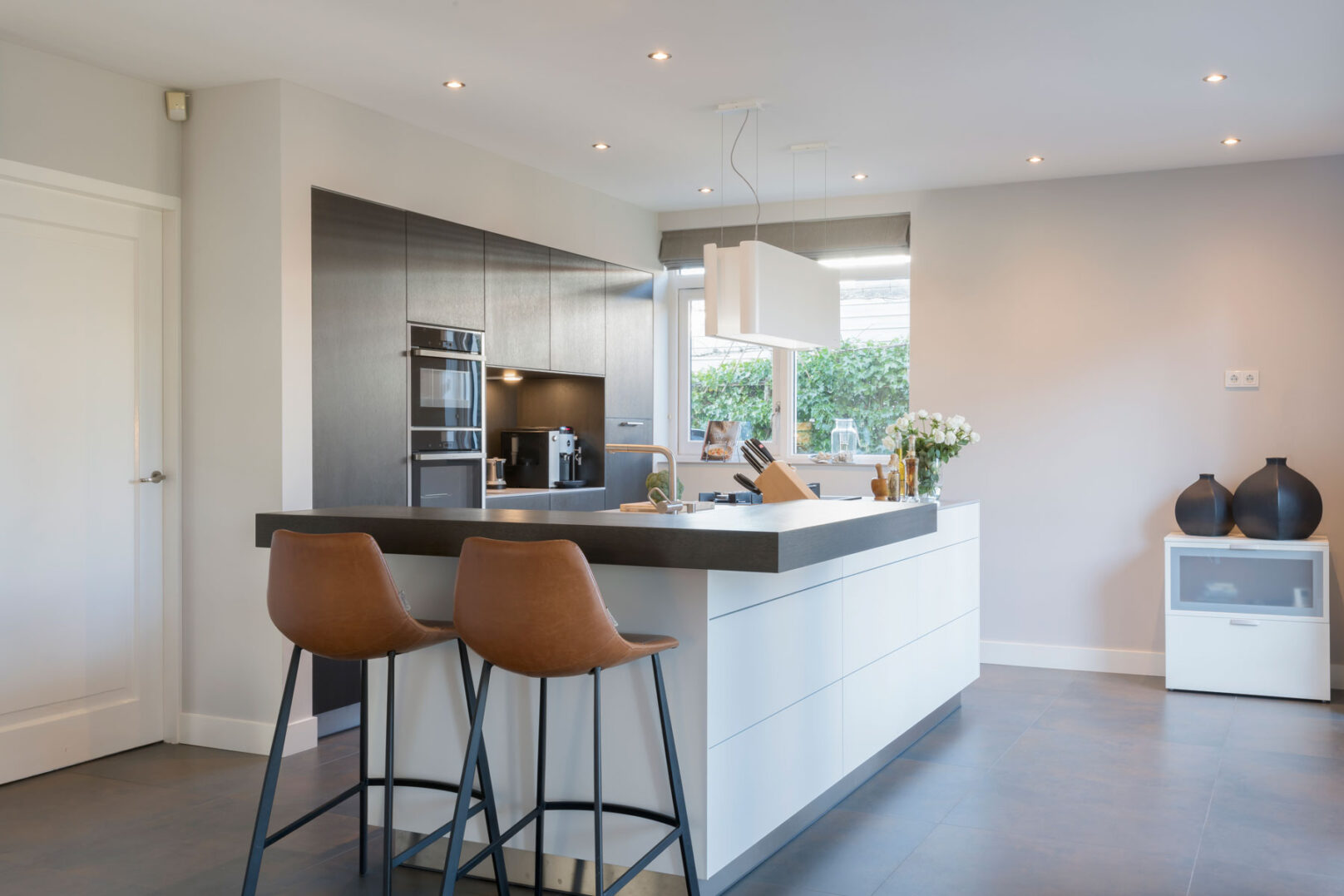 exclusieve keuken met hoek zitbar en hogekasten in zwart eiken